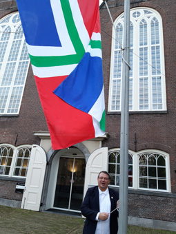 Koster Haro hijst de vlag voor de Oude Lutherse Kerk in Amsterdam