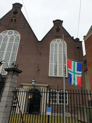 Voor de Oude Lutherse in Amsterdam hangt de Groninger vlag halfstok